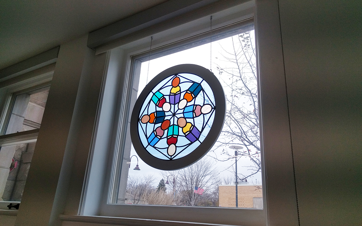 Stained glass kaleidoscope hanging in window