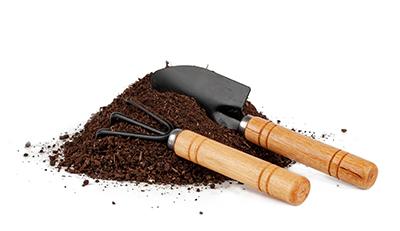 Gardening tools in a pile of soil